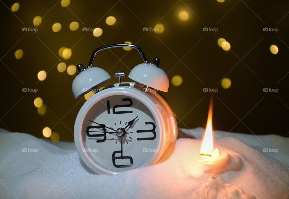 A clock with candles on the snow in the room