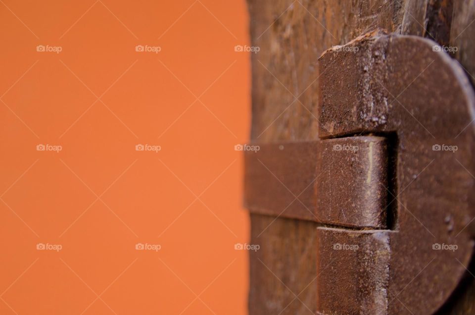 Rusted metal old brackets against orange background 