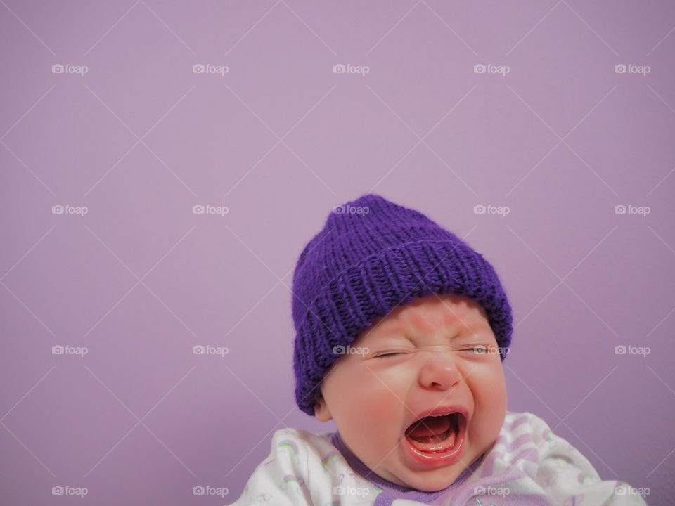 Crying baby with purple hat