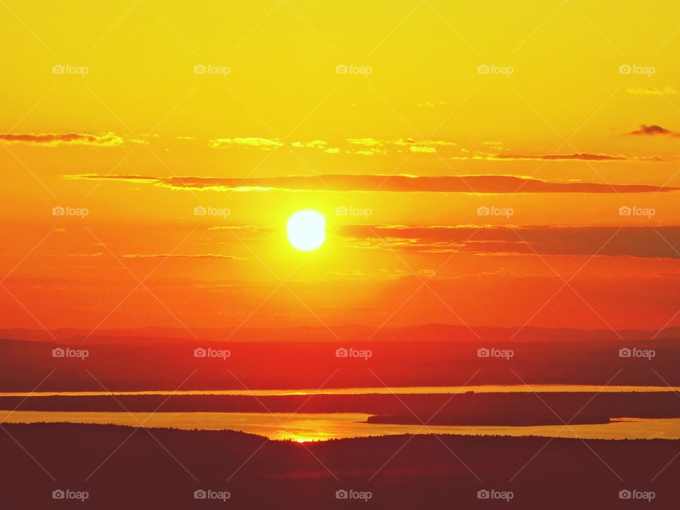 Sunrise vs Sunset - Sunset from the mountain top - I watched with an unwavering gaze, as a fiery orange orb of light slowly sank beneath the horizon, and threads of light lingered in the sky, mingling with the clouds