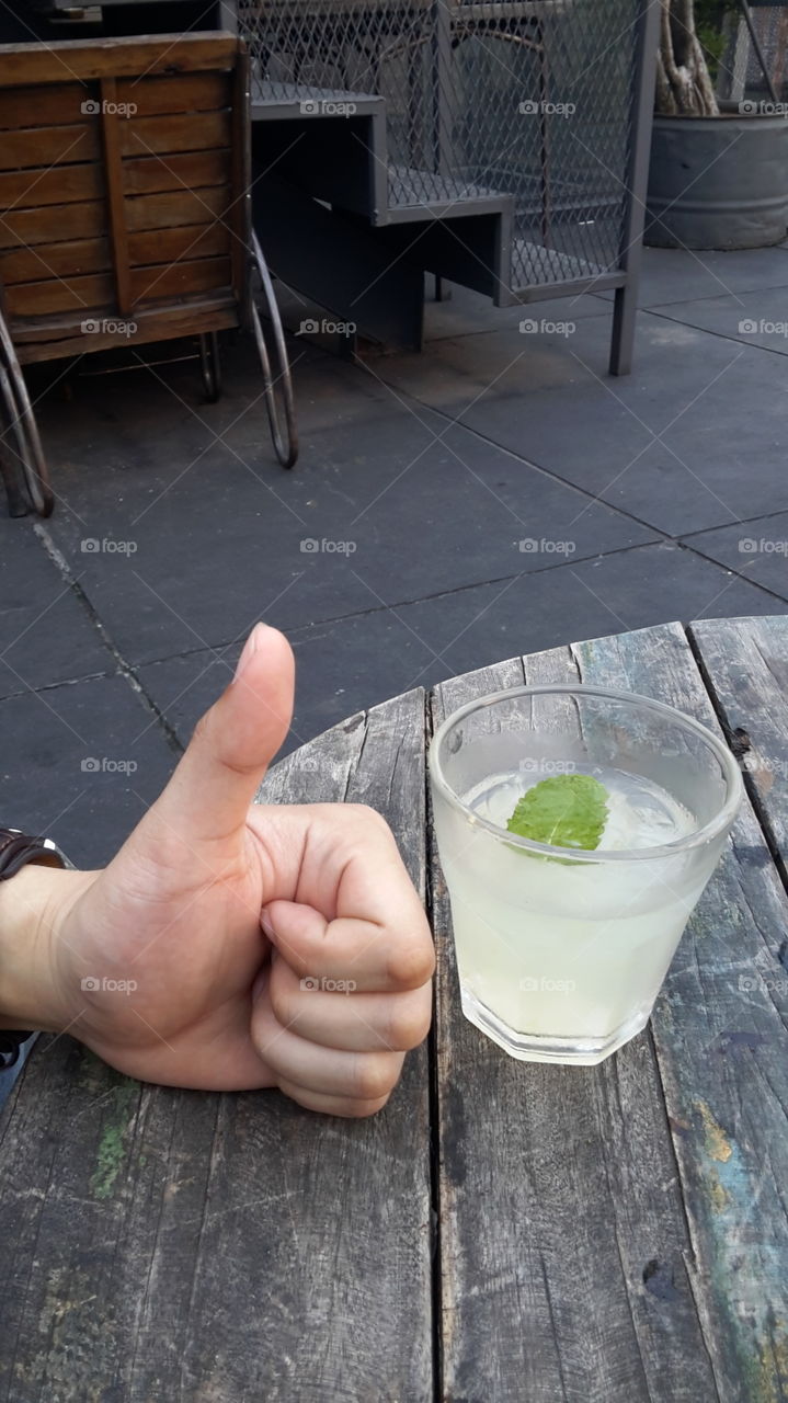 A thumb up and a glass of lychee mojito