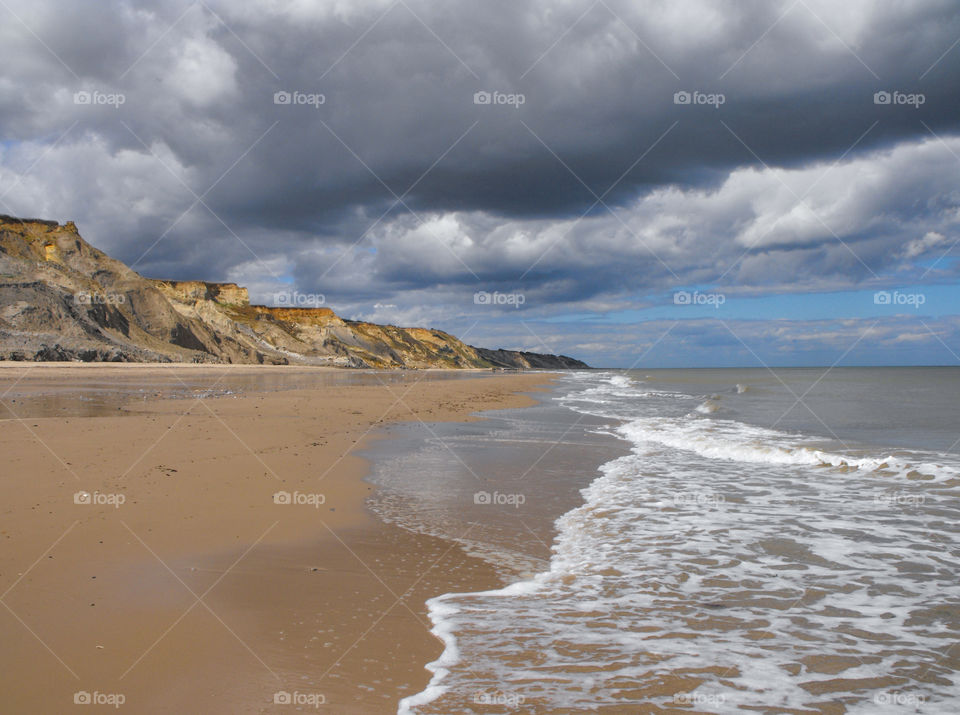 A spectacular beach with cliffs and dark clouds