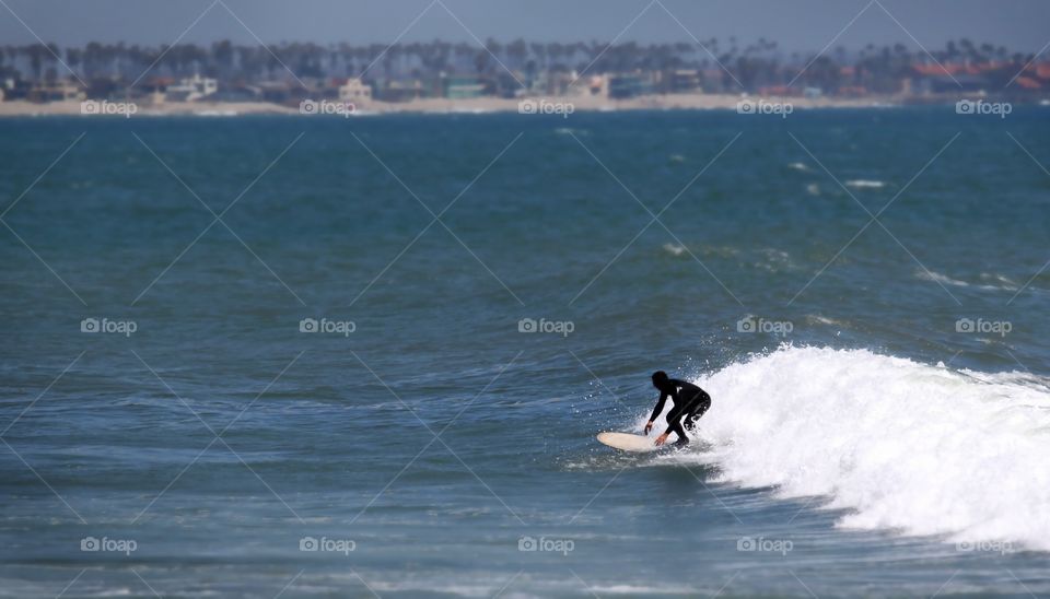 Surfer
Surfer riding a white wave towards the shore.