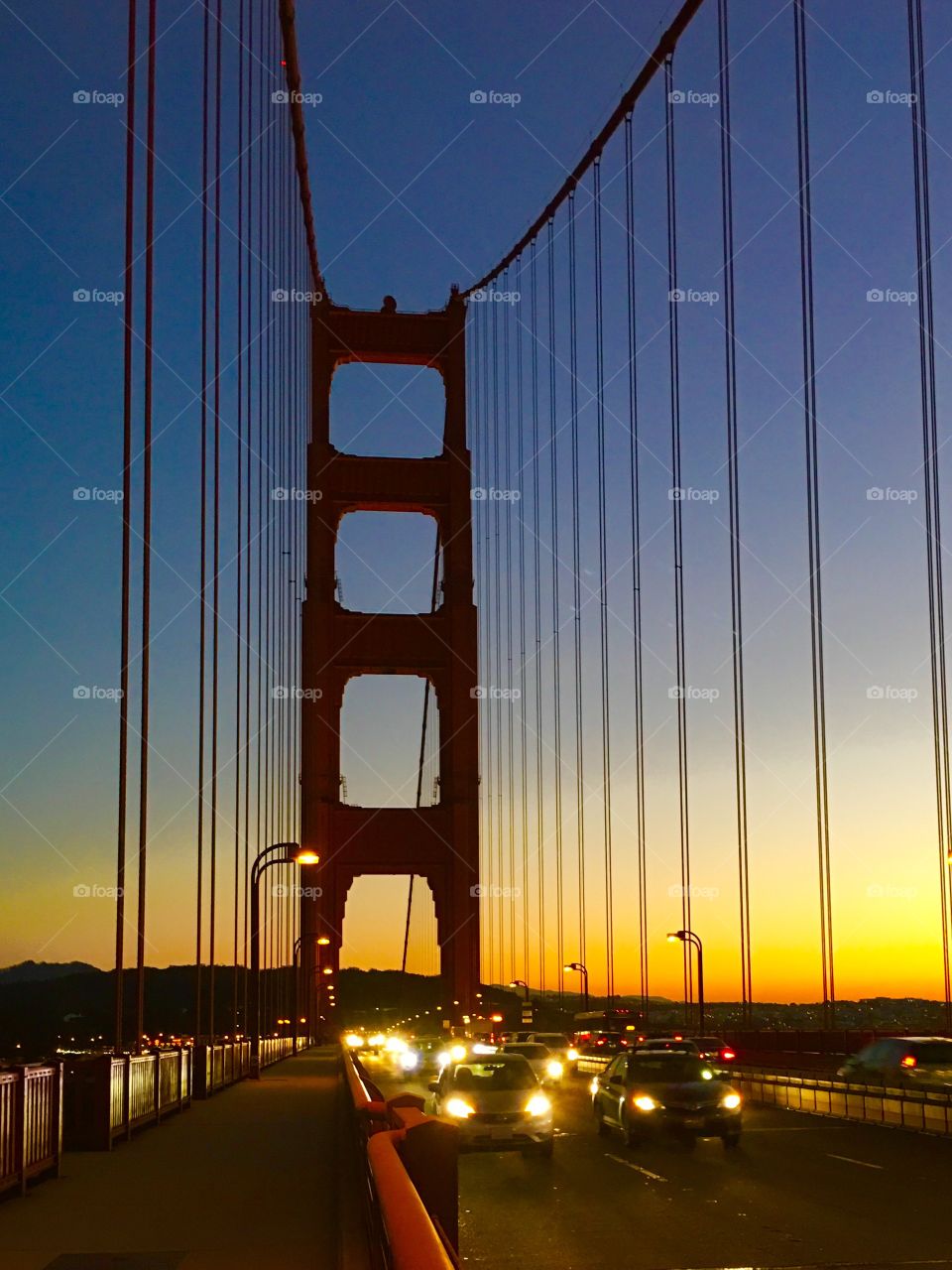 Traffic on Golden Gate Bridge at sunset. 