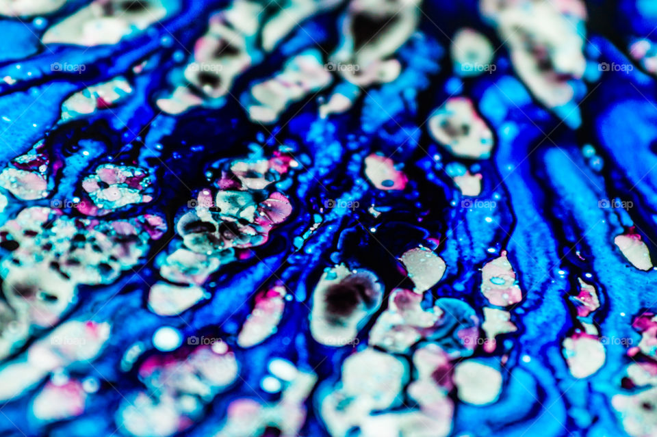 The ink to refill the printer cartridge was spilled onto the white washbasin and the paints blended into abstract drips and patterns.