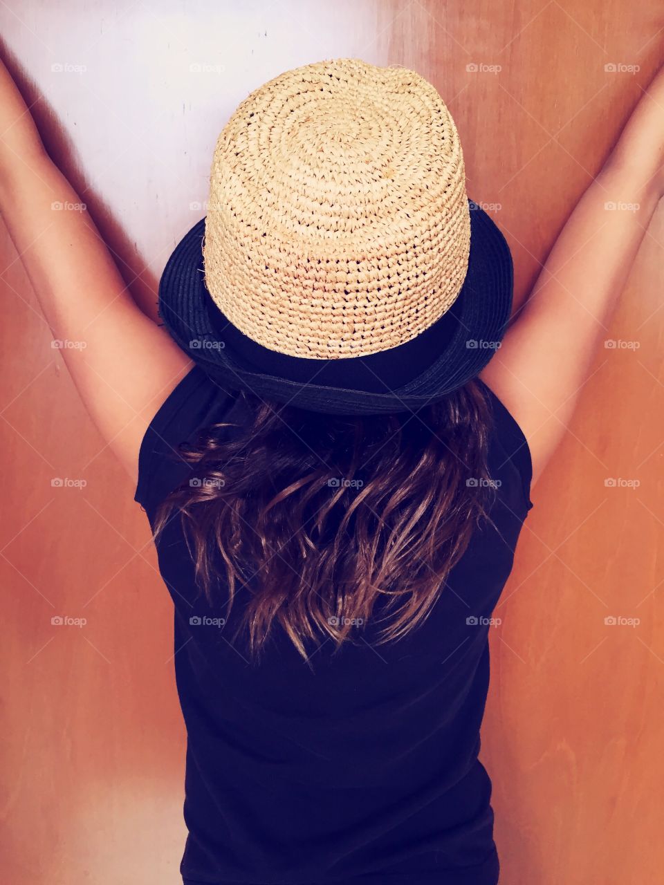 Rear view of young girl in blue shirt and hat
