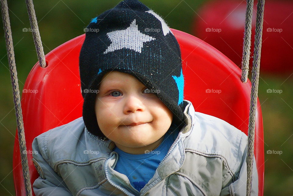 Happy toddler in the swing