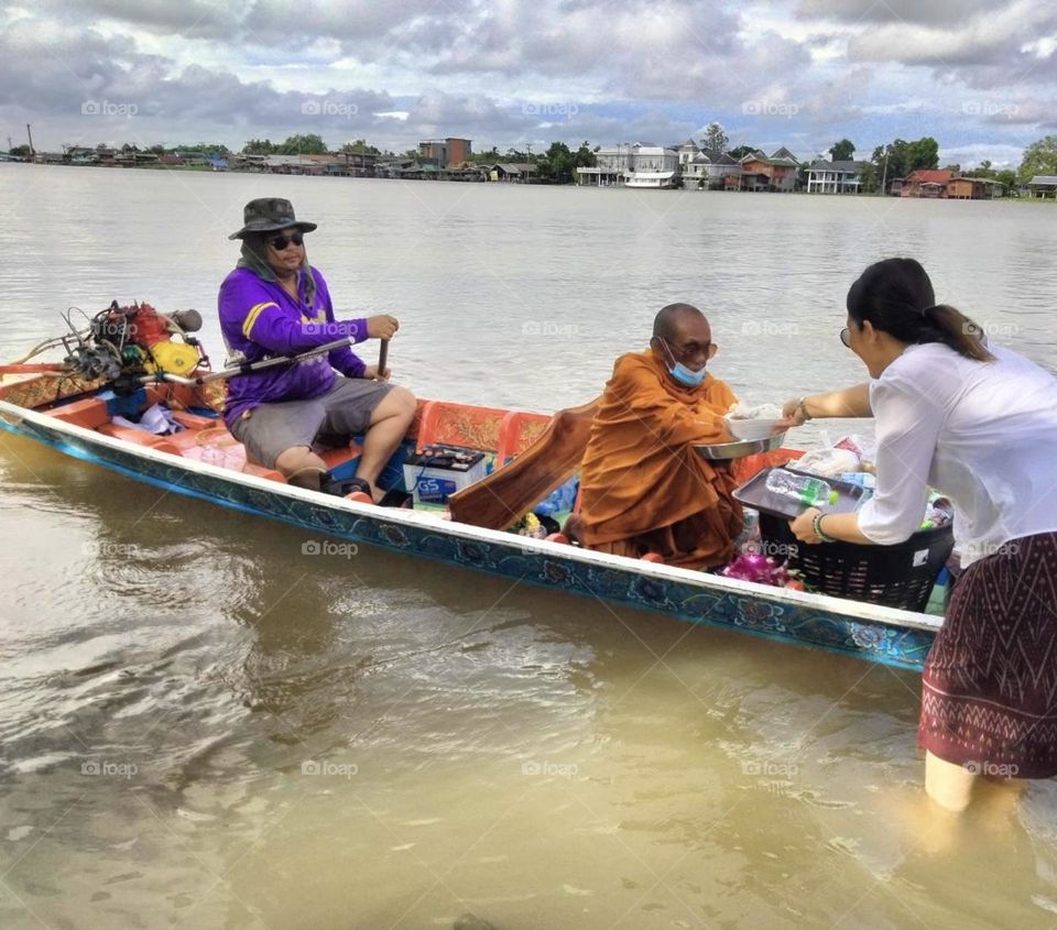 It's a ceremony of giving alms to monks by water, which happens only once a year.