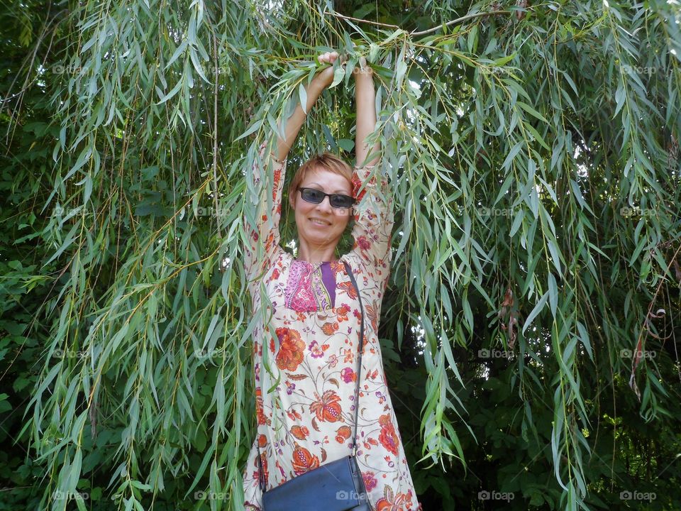 Cheerful girl on the background of a tree of green