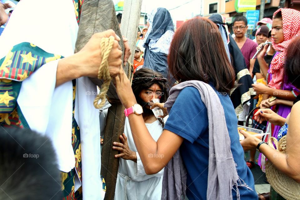 a catholic devotee is given water while reenact the death of jesus christ on good friday during holy week in cainta, rizal, philippines, asia