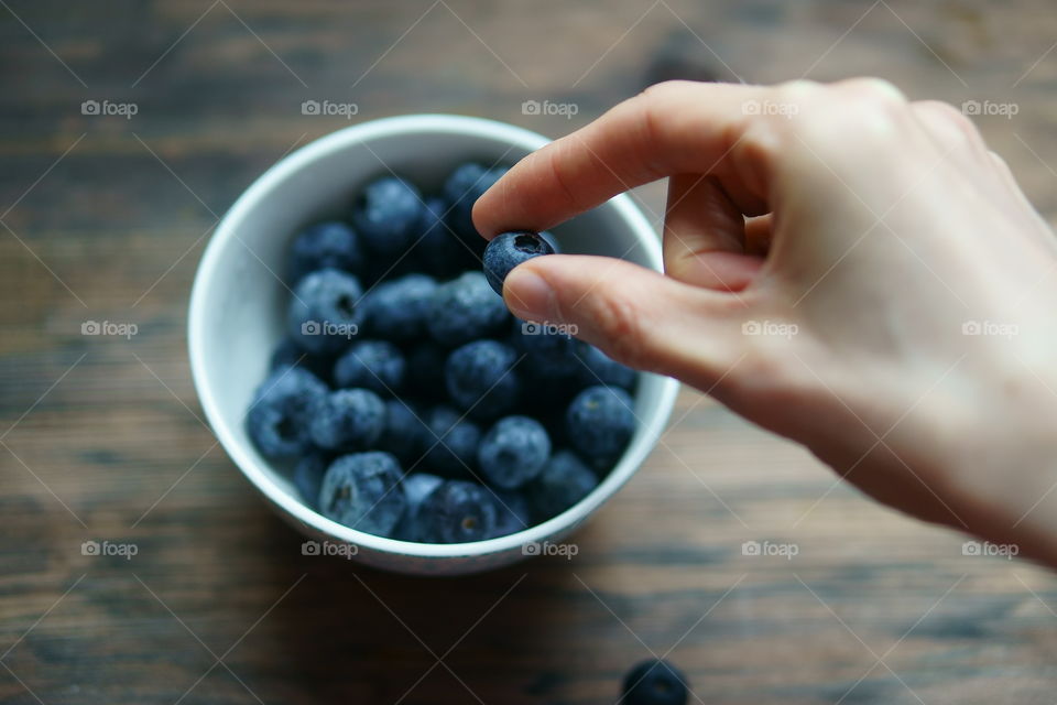 hand holding a blueberry