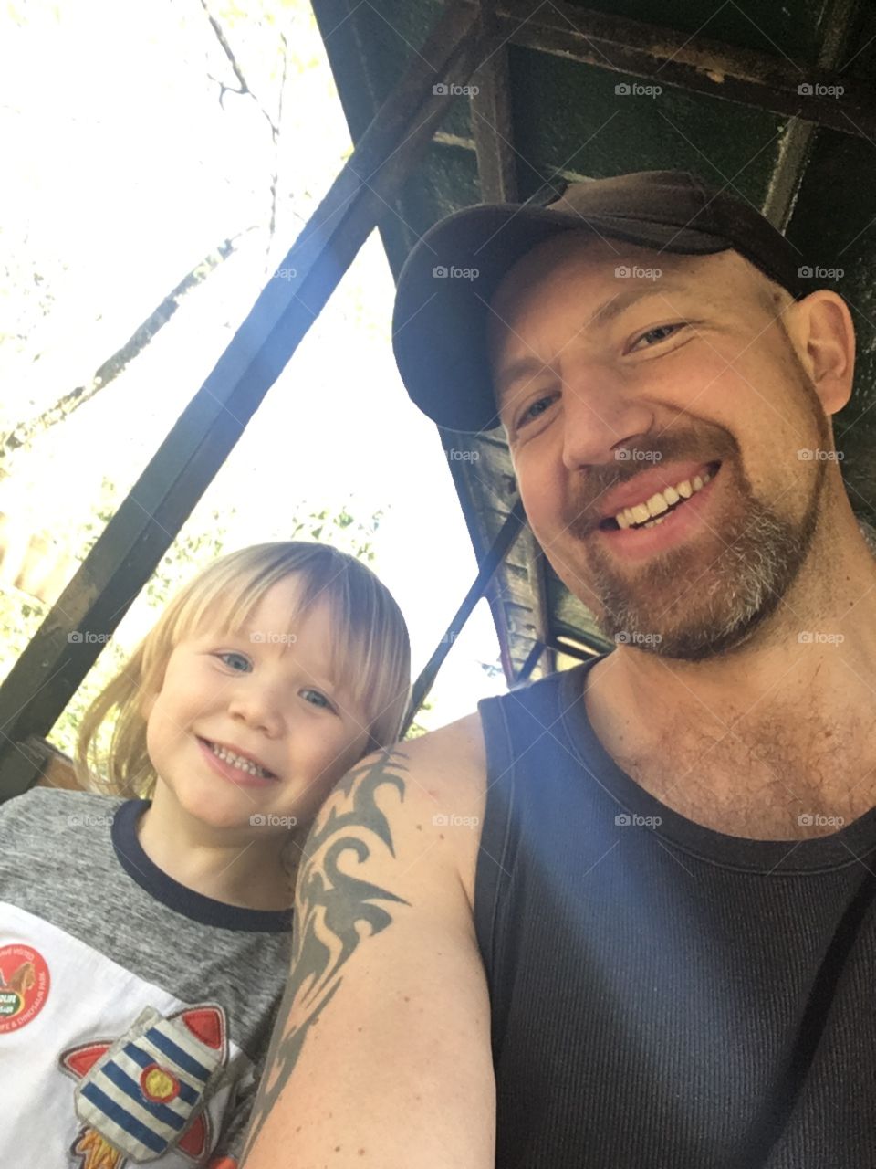 Young blonde child smiling and enjoying a ride on a train with his dad in North Devon. 