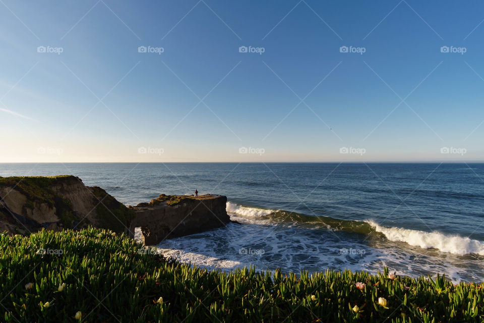 Man standing on the arch rock over the idyllic sea