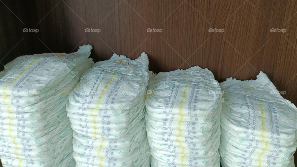 Baby diapers stacked on the shelf.