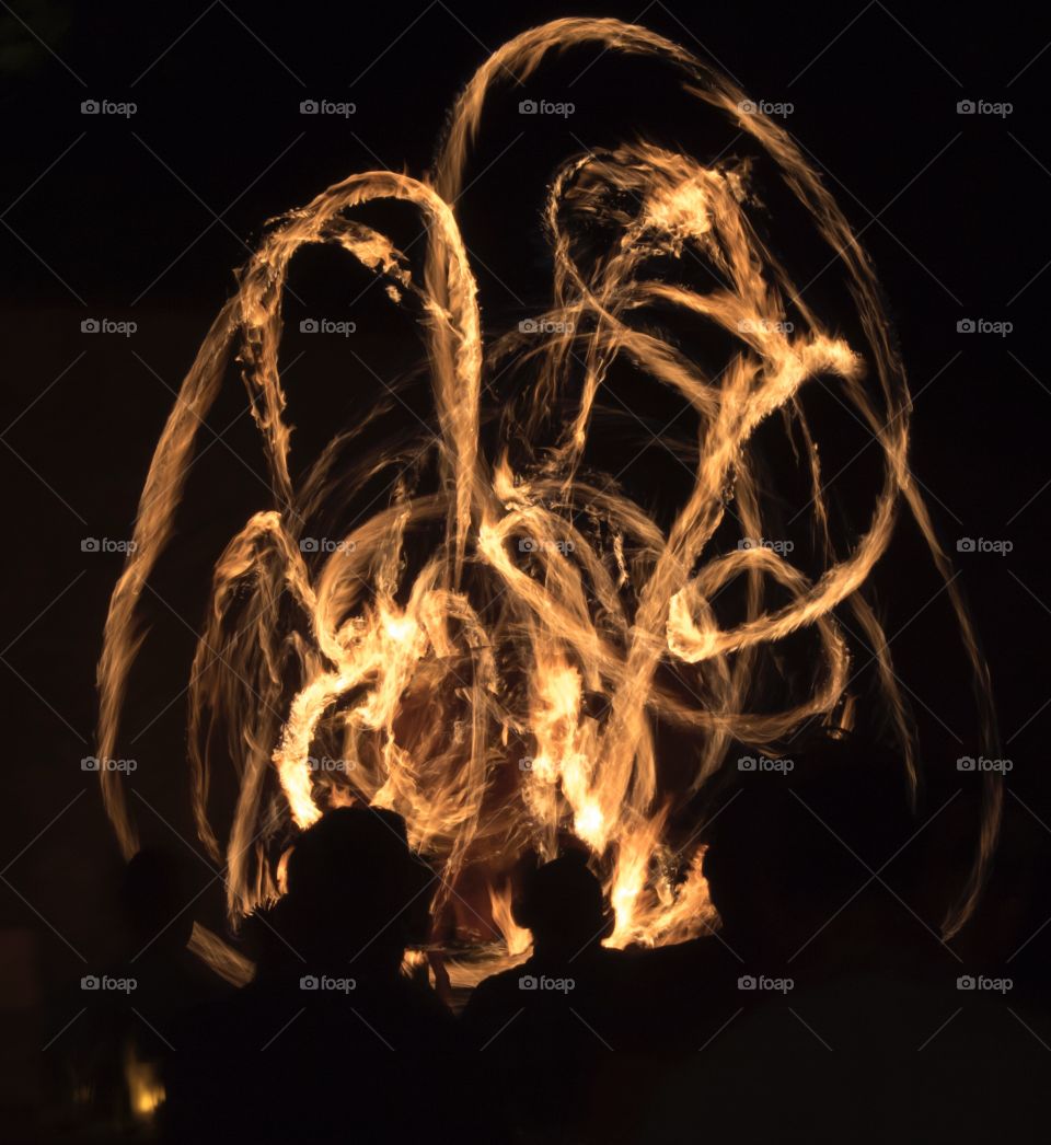 a long exposure shot of a hawaiian fire dance performance
