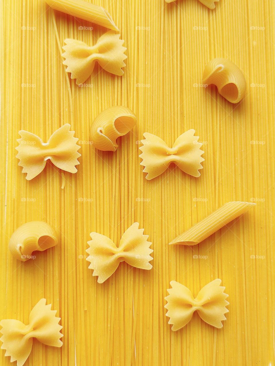 Yellow.  Fantasy with different shapes of pasta.  On long spaghetti are pasta "Farfalle" in the shape of a butterfly, horns "Pipe Righte" and "Rigatonni" in the form of tubes