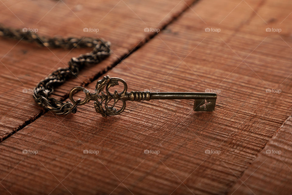 Old antique key on a wooden background