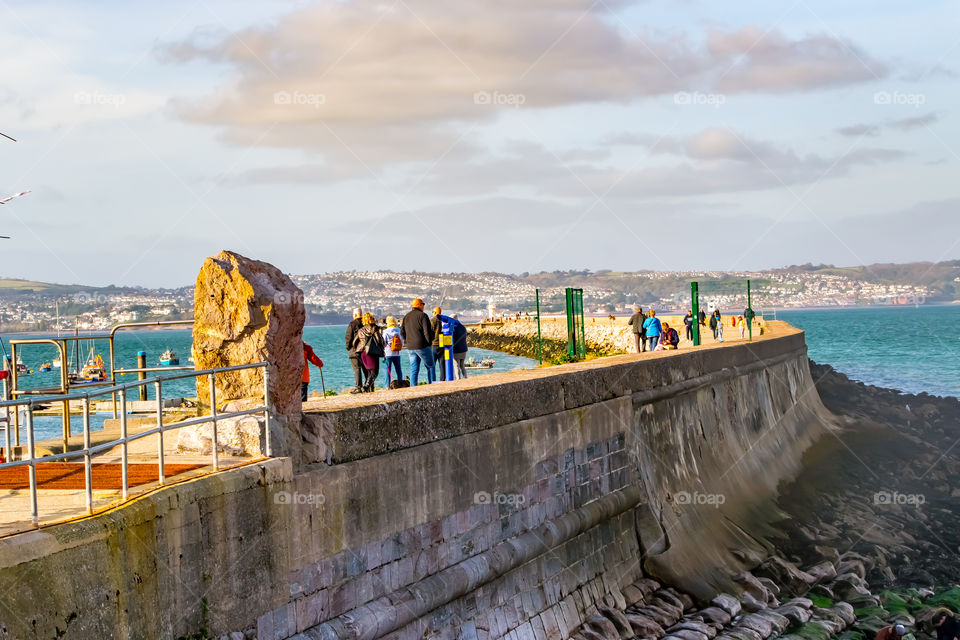weekend walkers strolling along Brixham breakwater