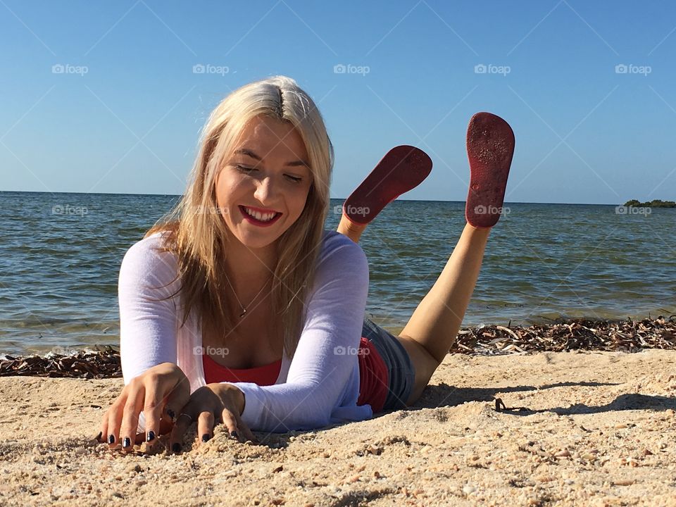 Woman lying on sandy beach