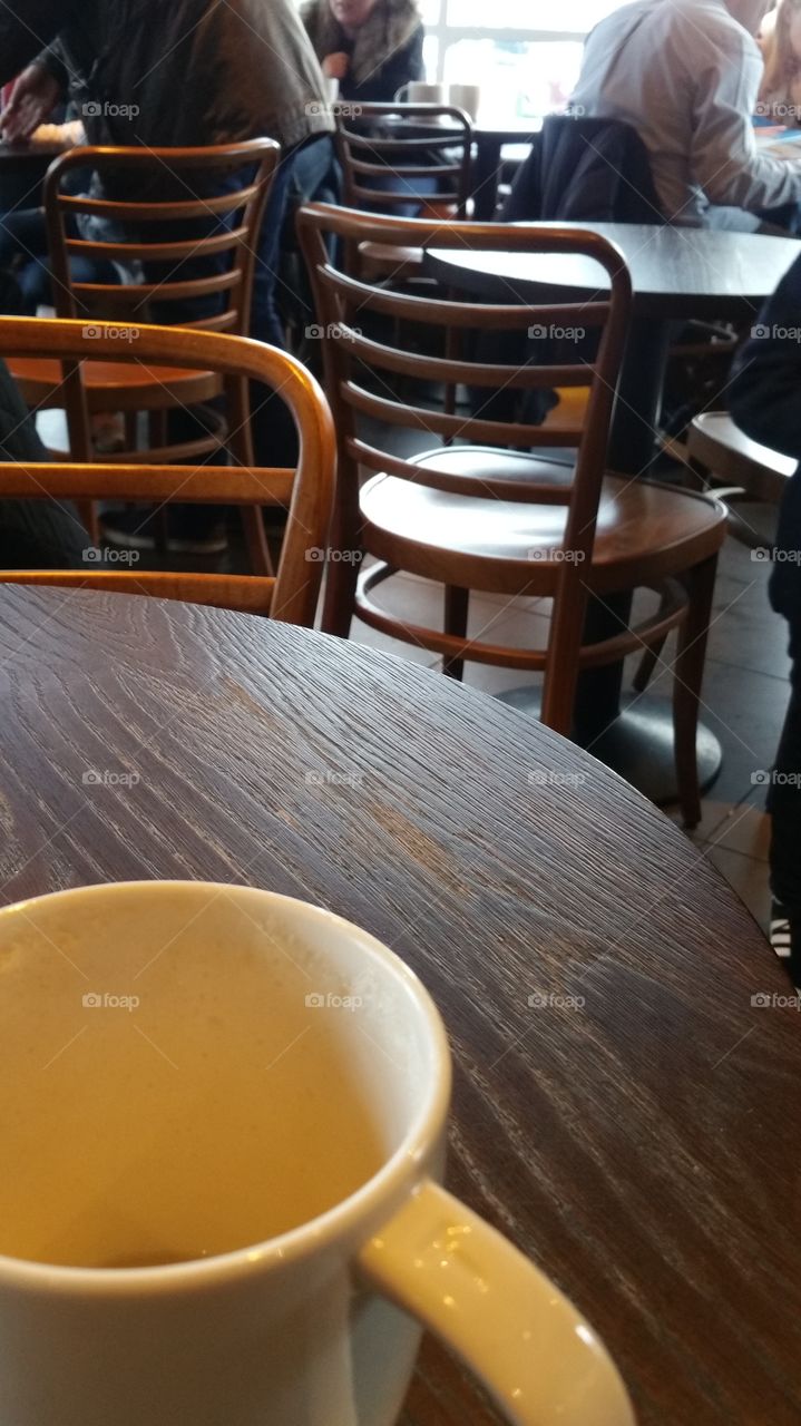 A café scene: chairs, tables, cups, blurry people