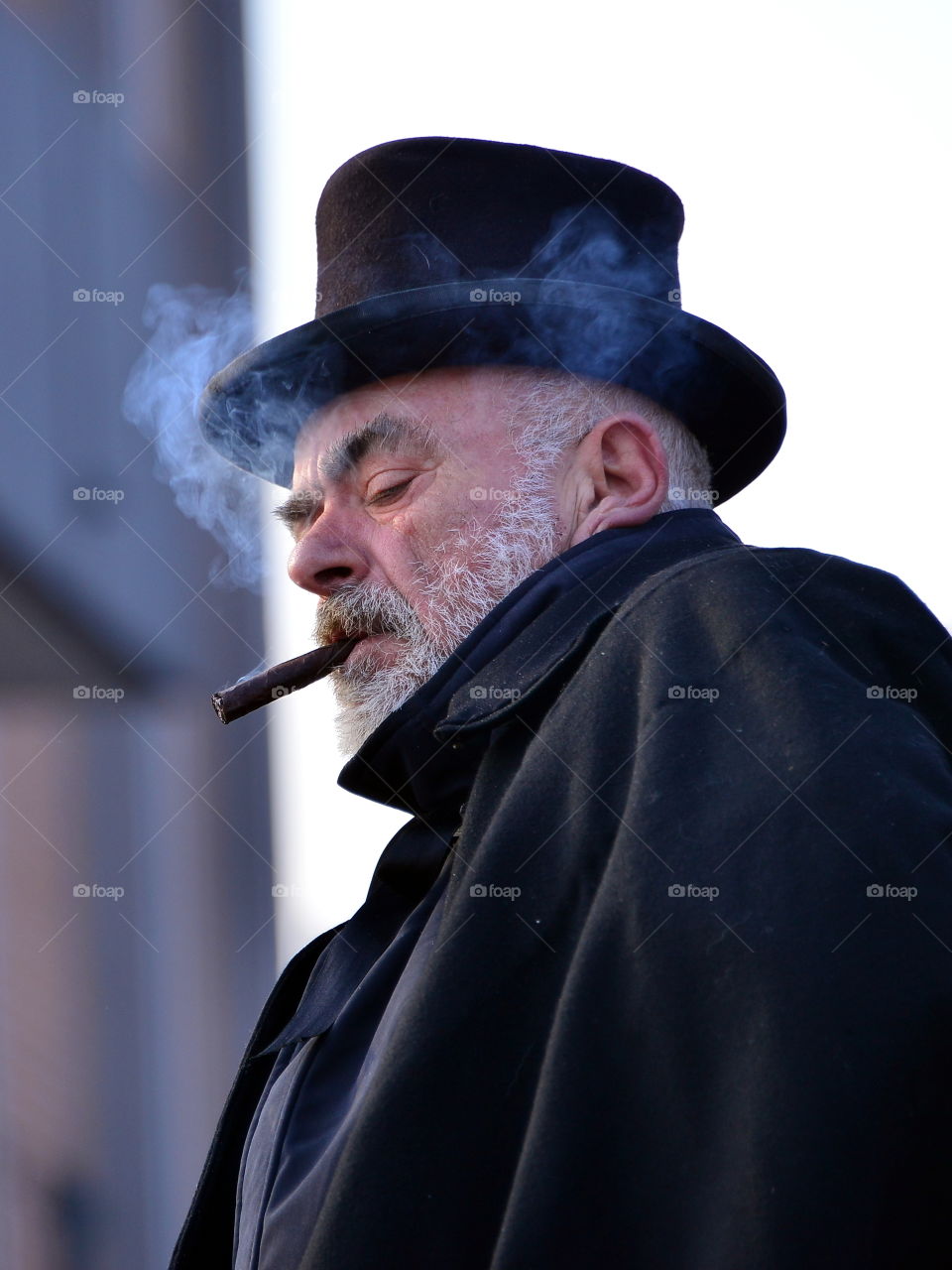 a man in a hat smokes a cigar