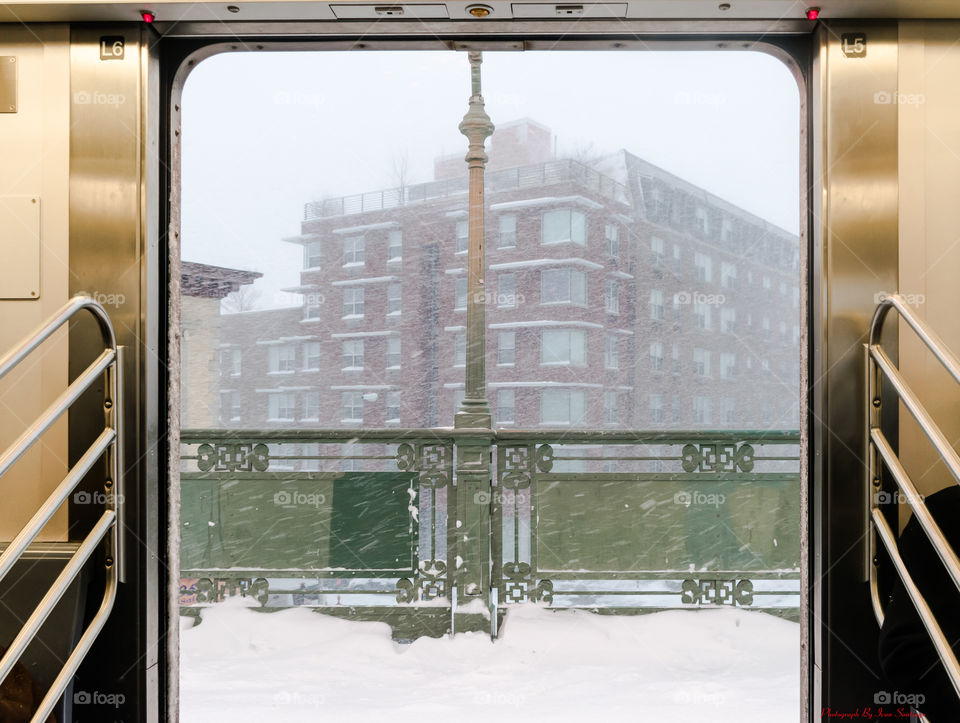 Open Train Doors looking at the Winter Snow Storm in the City