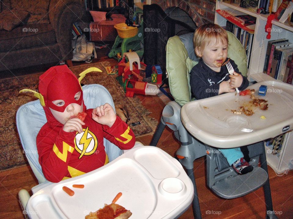 Young Boys Eating In Highchairs
