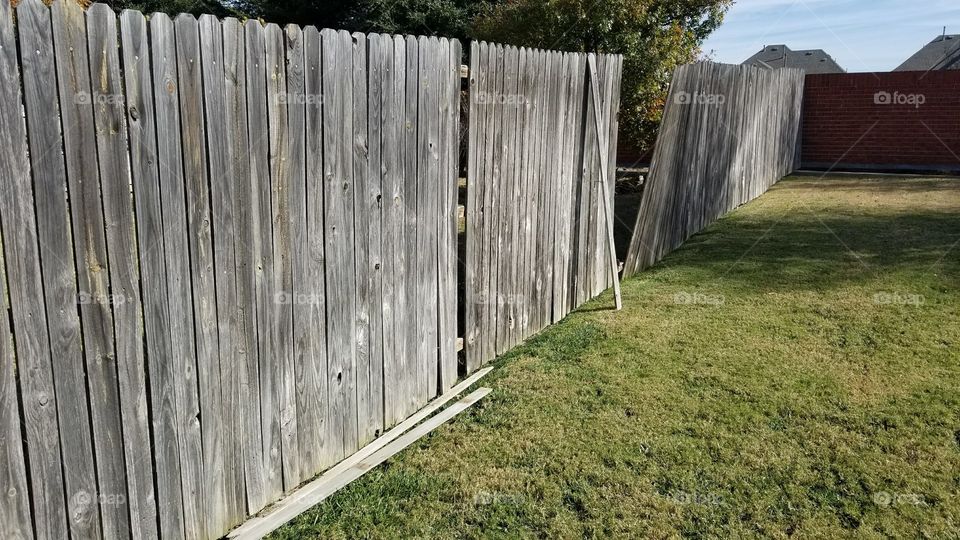 Broken fence in backyard - wooden slats knocked over