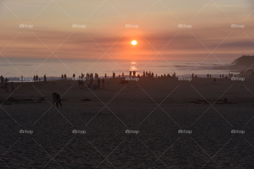 Silhouette of people enjoying sunset on a beach