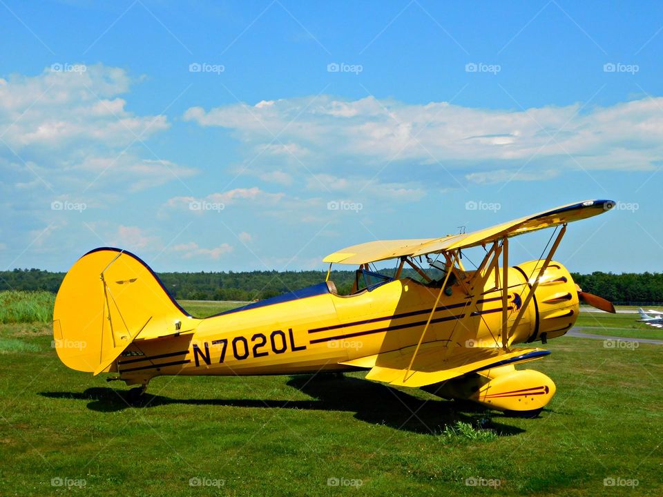 Yellow bi-plane on the grassy airstrip - Yellow is the color of happiness, and optimism, of enlightenment and creativity, sunshine and spring.