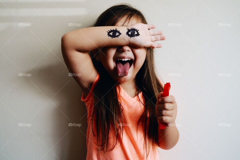 Little girl with eyes drawing on hand
