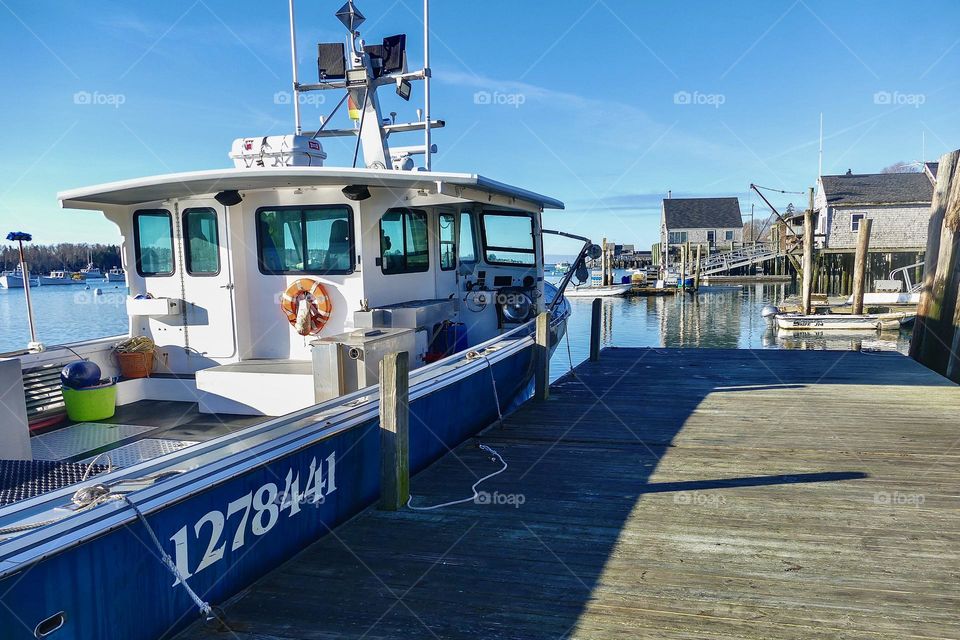 A lobster boat sits in preparation for the day in all small Maine harbor.