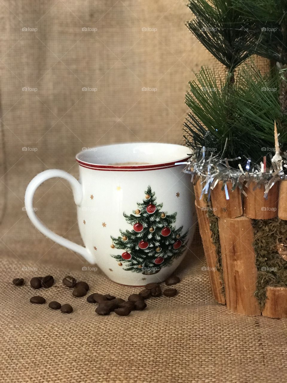 Coffee cup and Christmas decor on sackcloth background.