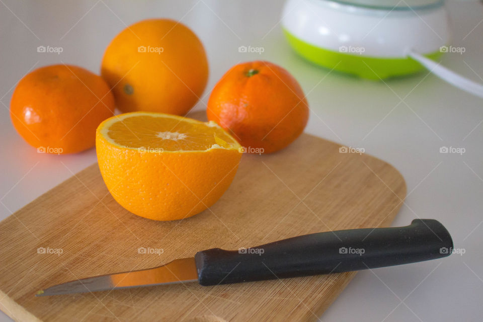 Orange and cutting board on white background