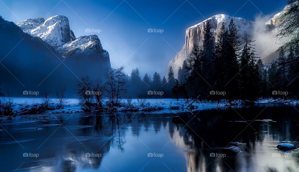 Beautiful snowy natural landscape by the lake in the narrow valley
