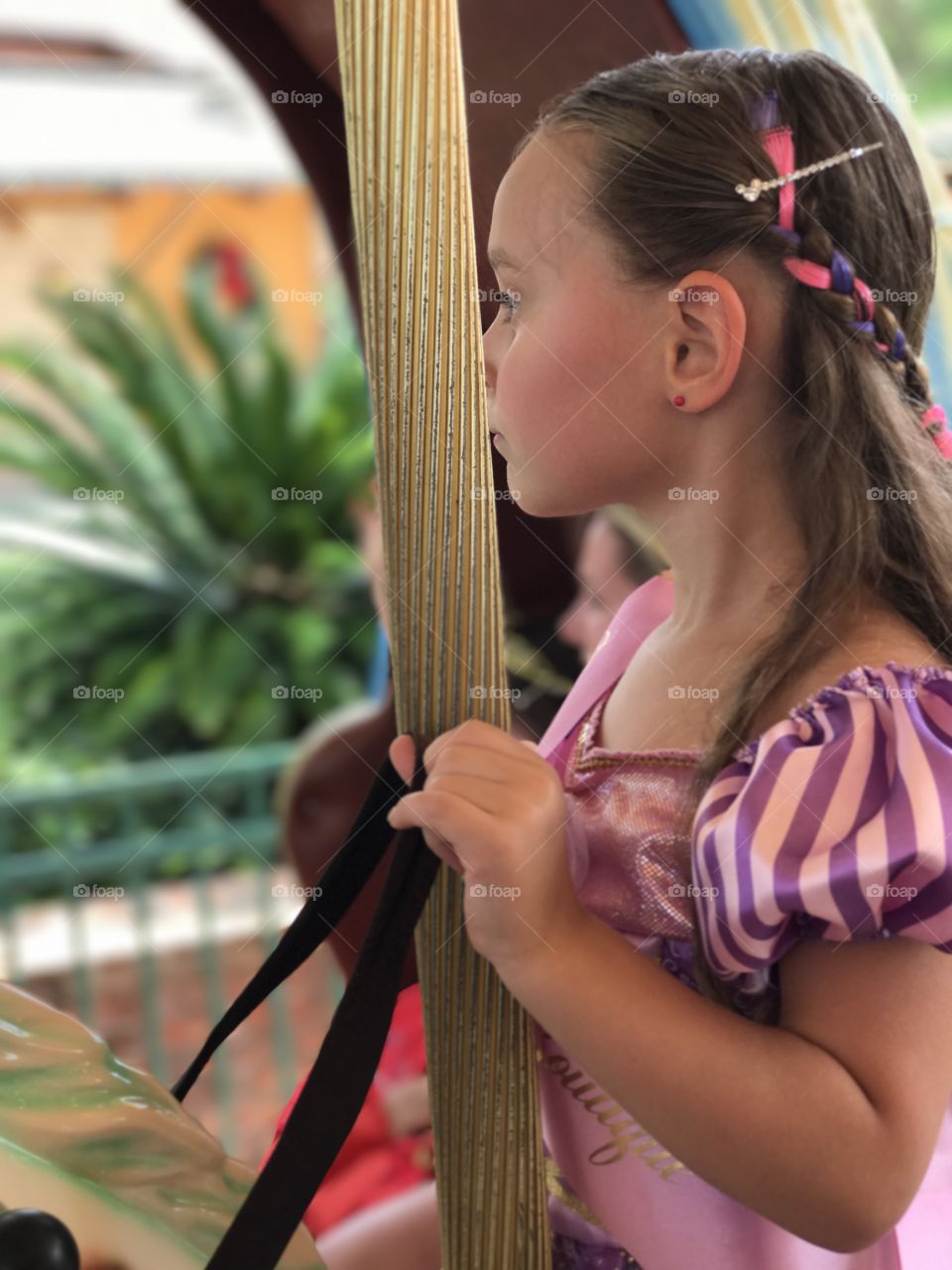 Side view of little girl holding pole