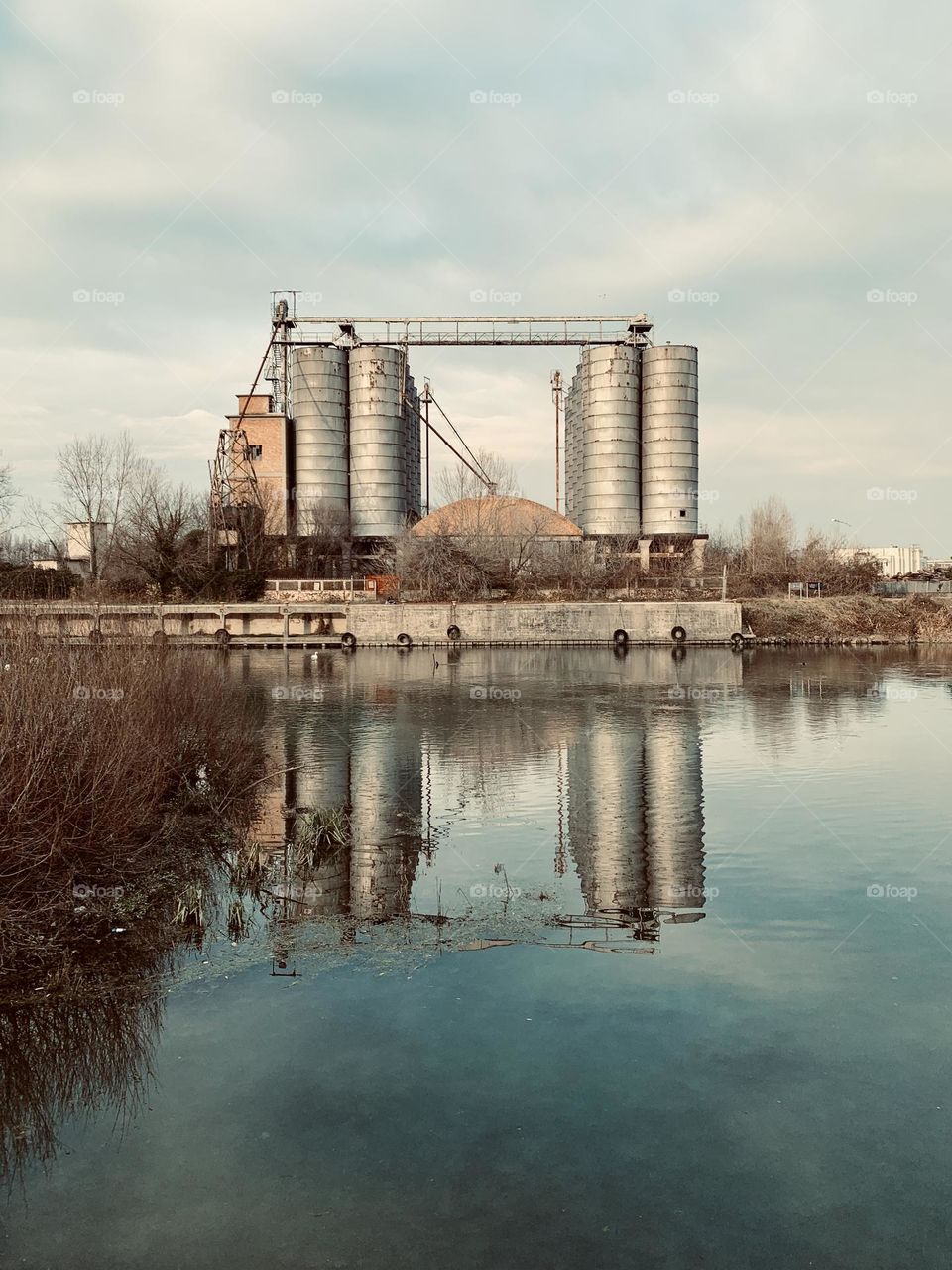 On the bank of the Sile river, near Treviso, an old industrial structure with silos used to store grain brought by river boats from the ports of Venice