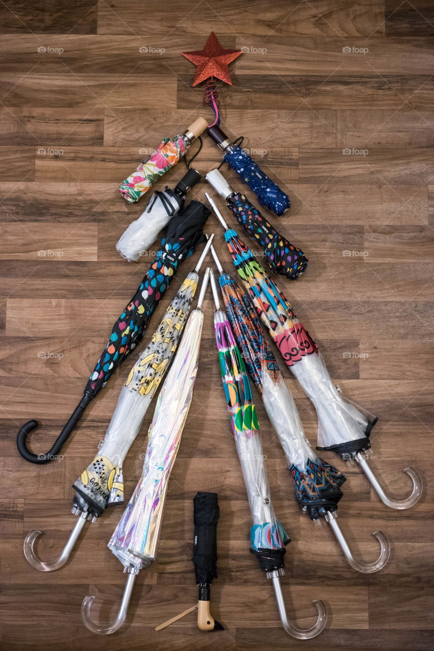 Flat lay of multiple umbrellas placed together to make the shape of a Christmas tree
