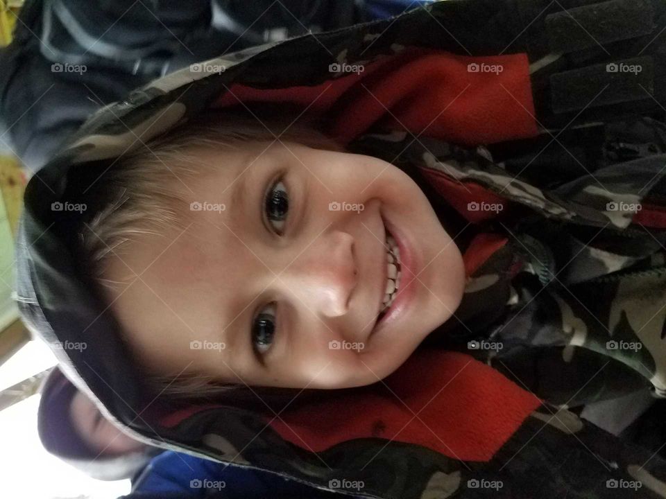 Smiling boy wearing camouflage hoodie