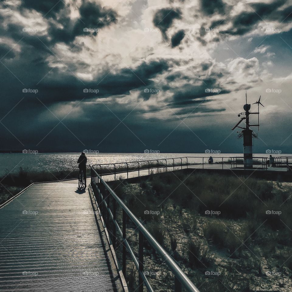 Person riding bicycle on boardwalk