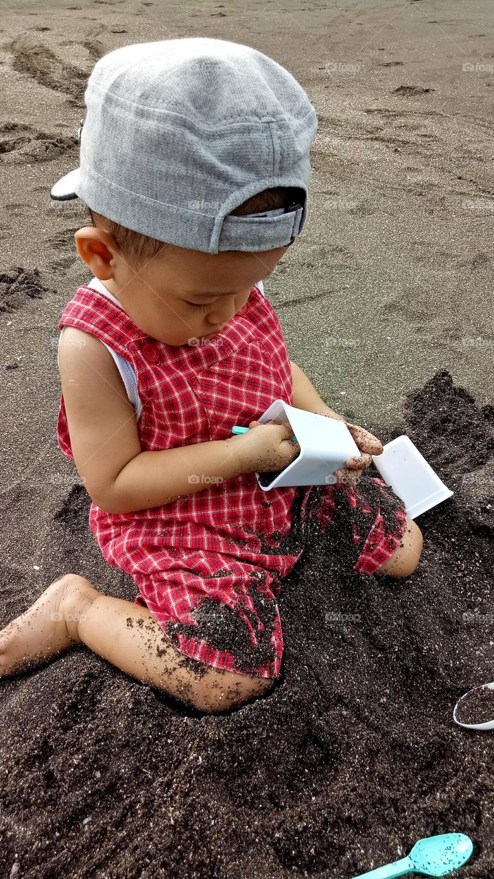 a boy play sand with seriously