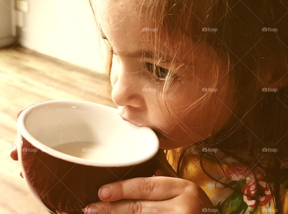 little girl sipping milk