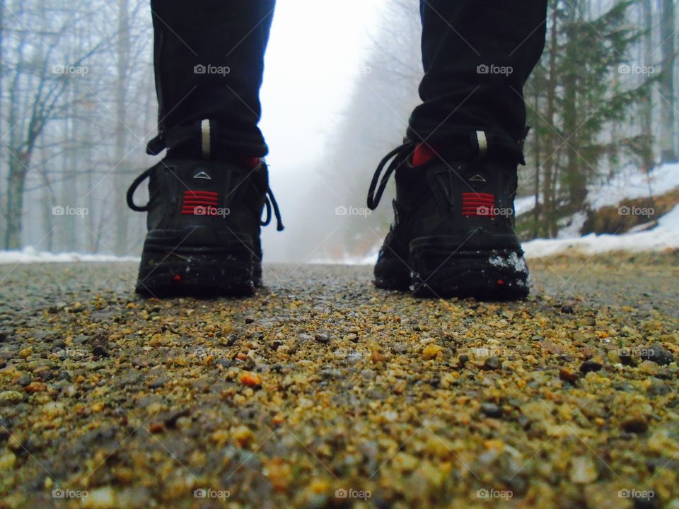 Close up of mountain boots with fog  and snow ahead