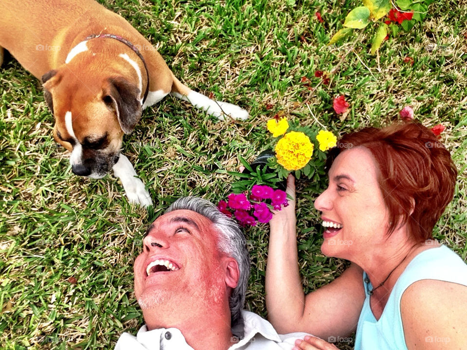Couple with dog and flowers in backyard