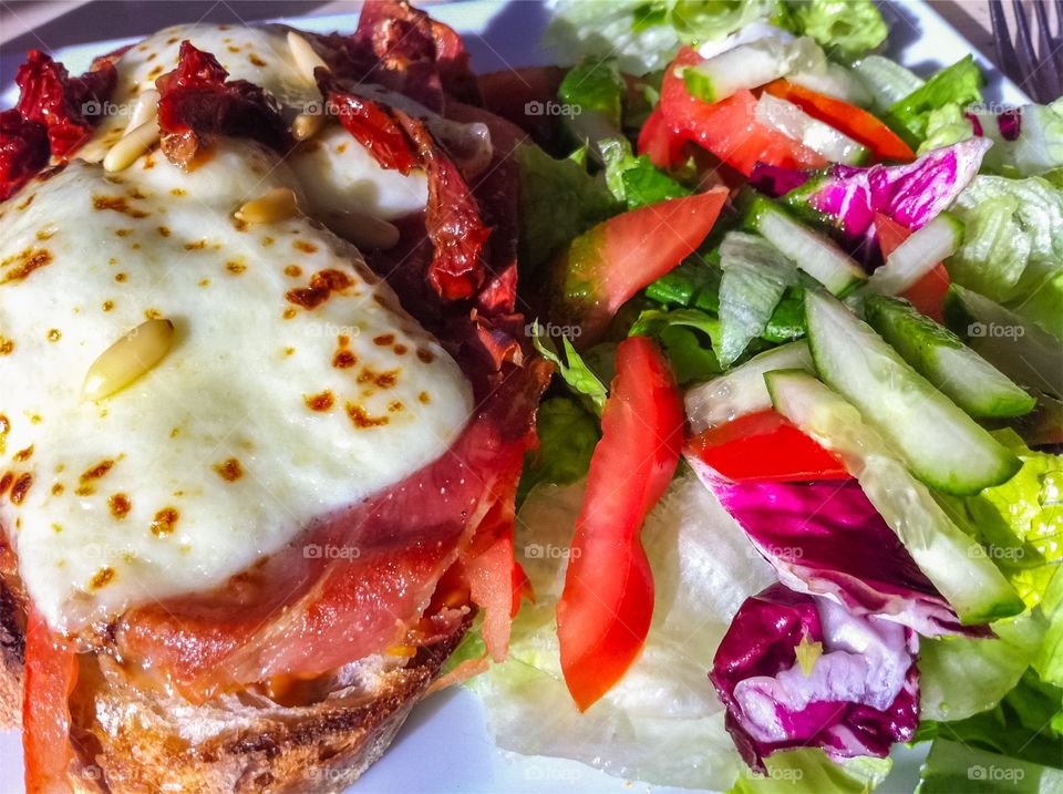 Lunch time with grilled cheese and ham sandwich and fresh vegetables.