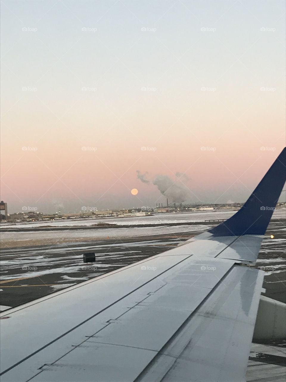 Window seat view of the moon at sunrise