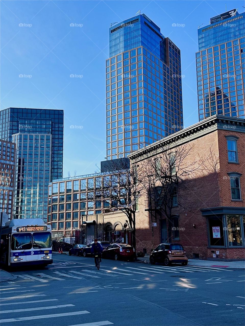 These ultramodern high rise buildings behind the old fashioned ornamented brownstone building are at the intersection of „Manhattan Ave“ and „Box St“ in „Greenpoint“, Bklyn. Across the street is the „B43“ bus stop. 2024. Hypnotic Productions