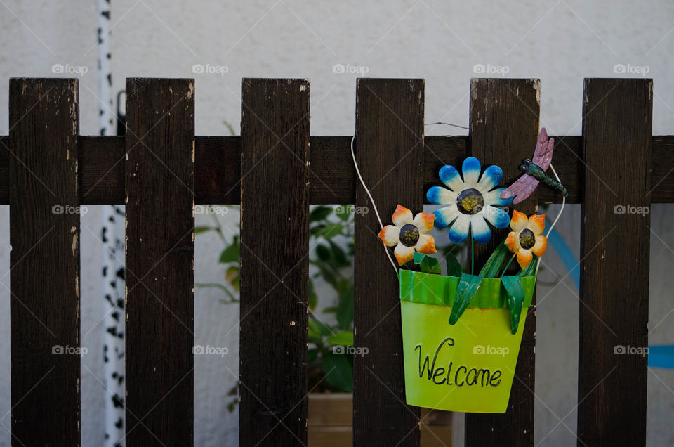 welcome . plate at a fence