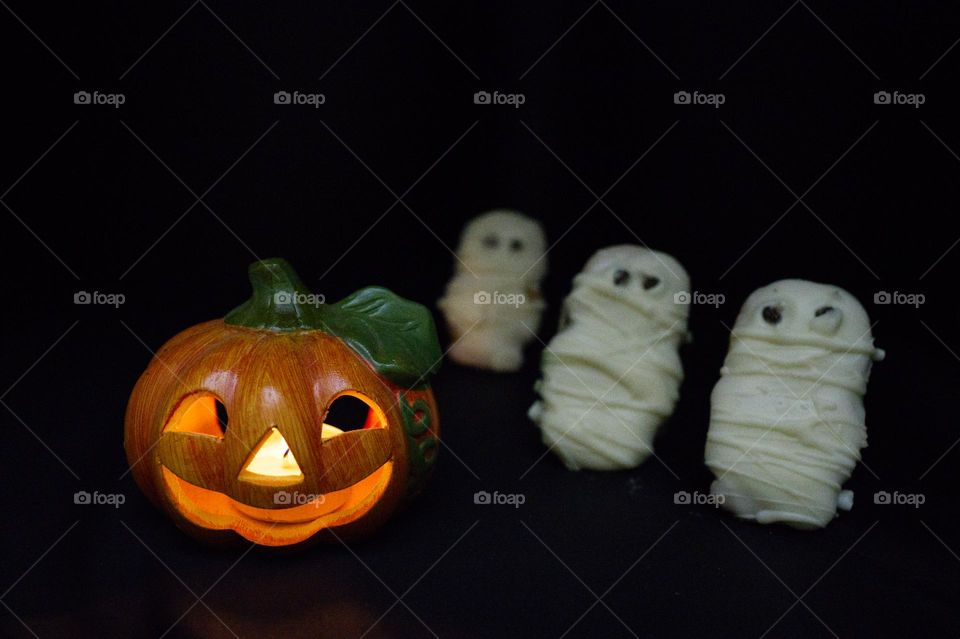 ceramic pumpkin with three chocolate chip cookies like zombies