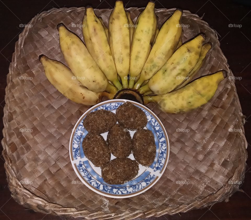 Banana and sweet made by rice flour for evening tea. These food kept on a container made by coconut leaves.